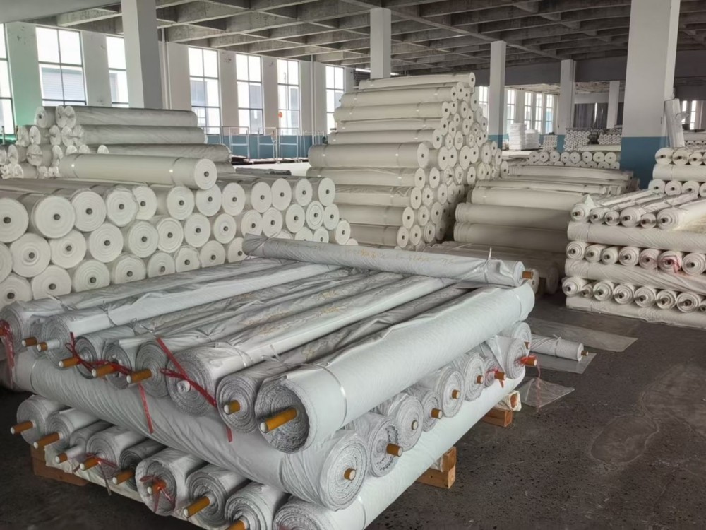 In-stock greige fabric rolls stacked in the Mifu Textile warehouse, ready for fast custom colour dyeing